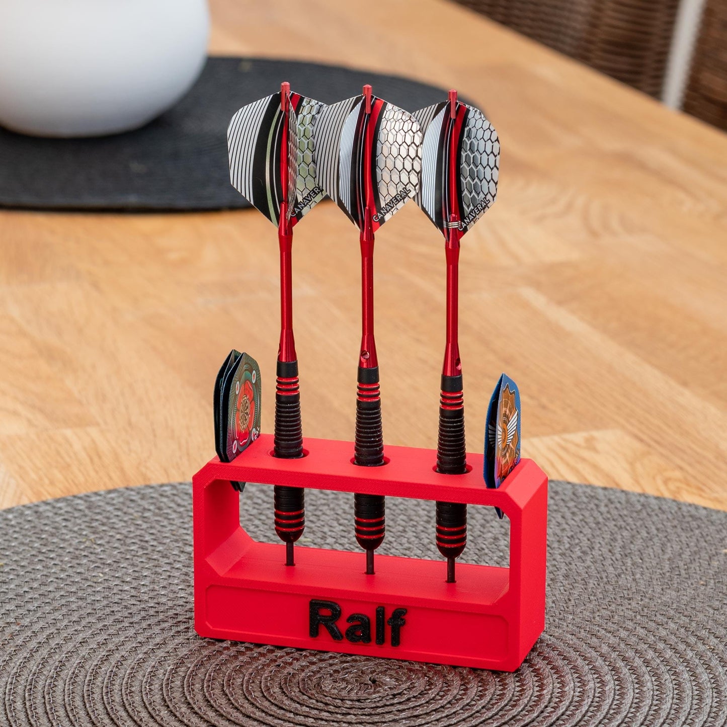 Roter 3D-gedruckter Darthalter aus nachhaltigem PLA mit dem Namen 'Ralf', hält drei Darts und zwei Flights