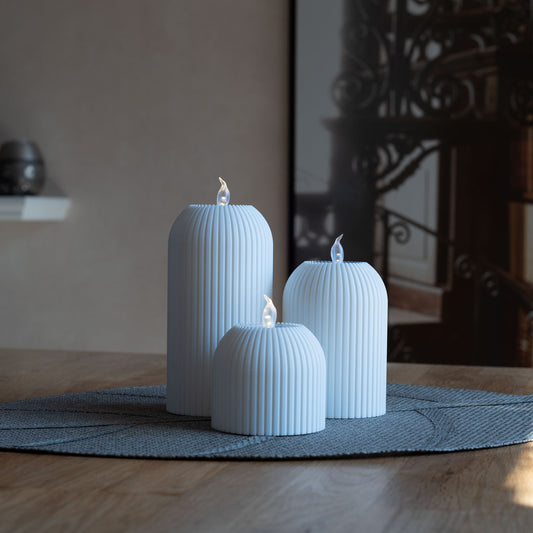 Drei nachhaltige Teelichter aus PLA, 3D-gedruckt, in verschiedenen Größen mit gerillter Oberfläche auf einem Tisch