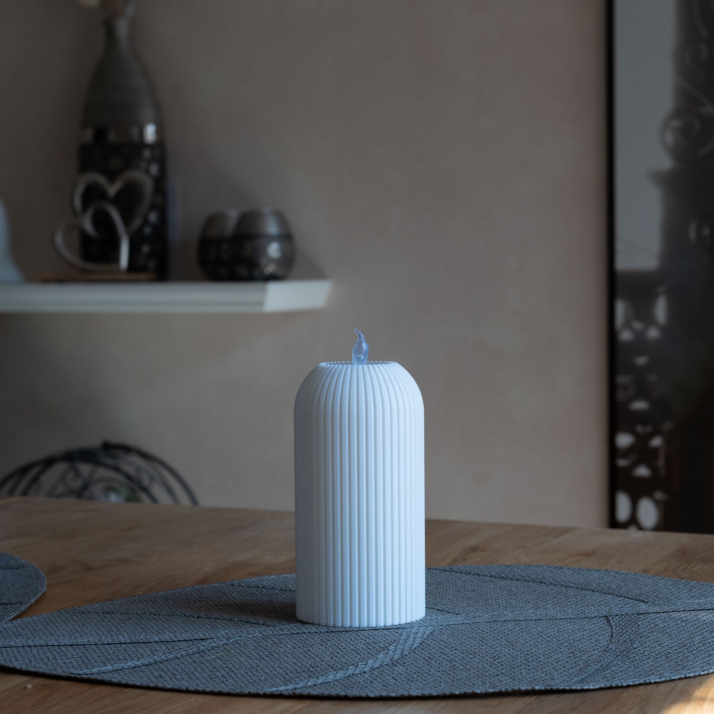 Nachhaltiges, weißes Teelicht mit vertikalen Rillen, 3D-gedruckt aus PLA, steht auf grauem Tischset