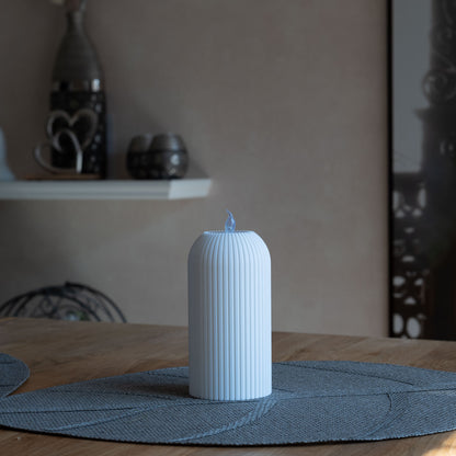 Nachhaltiges, weißes Teelicht mit vertikalen Rillen, 3D-gedruckt aus PLA, steht auf grauem Tischset
